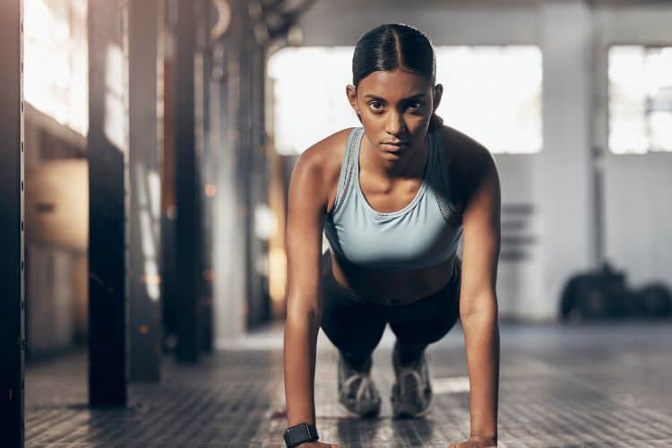 Woman performing squat to press with dumbbells during a 10-minute full body strength workout