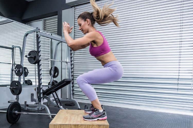 Woman performing squat jumps during 30-minute full body circuit workout
