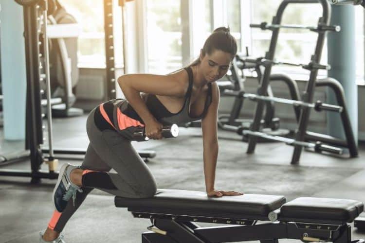 Woman performing 30 minute strength training dumbbell workout squat to press