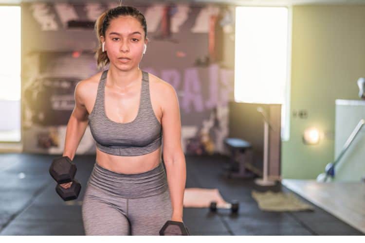 Woman performing dumbbell lunges during 45-minute full body circuit workout