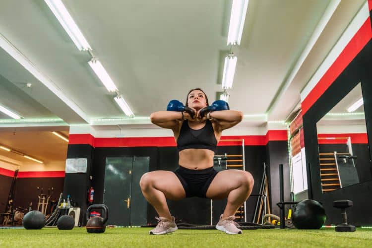 Woman performing kettlebell squats during a 45-minute lower body HIIT workout