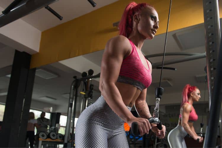 Woman performing Tricep Pushdown on a machine during a 30-minute arm workout