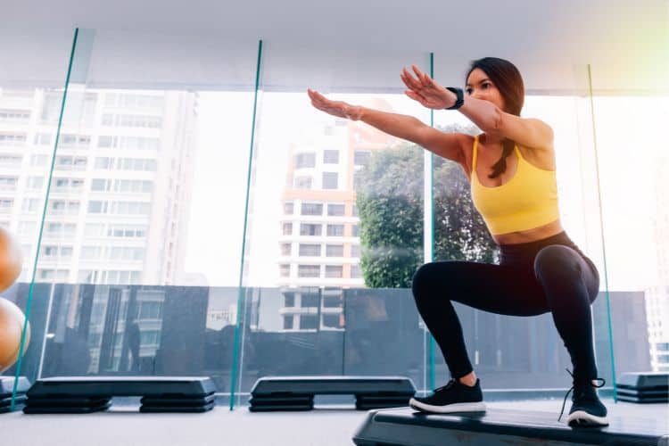 squat for lower body strength in a 30-minute full body bodyweight workout