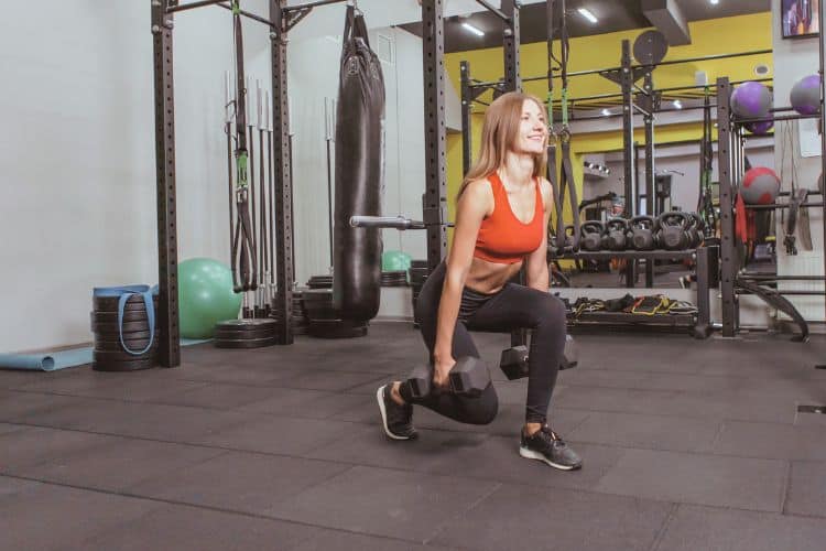 Woman performing dumbbell squats for legs and glutes workout