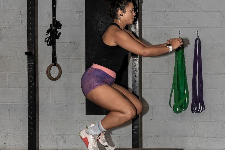 Woman performing squat jumps during a 15-minute full body superset workout