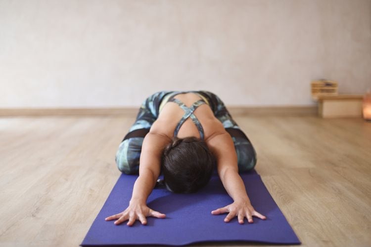 Beginner practicing yoga in Child’s Pose during 30-minute routine