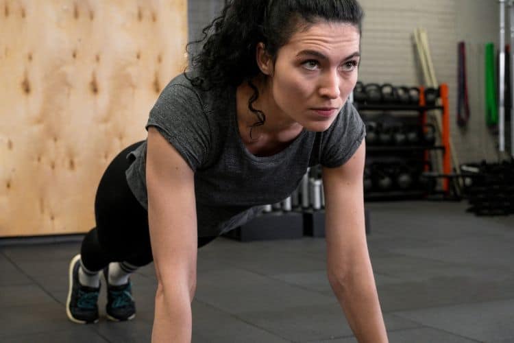 Woman performing push-ups during 30 minute upper body bodyweight workout