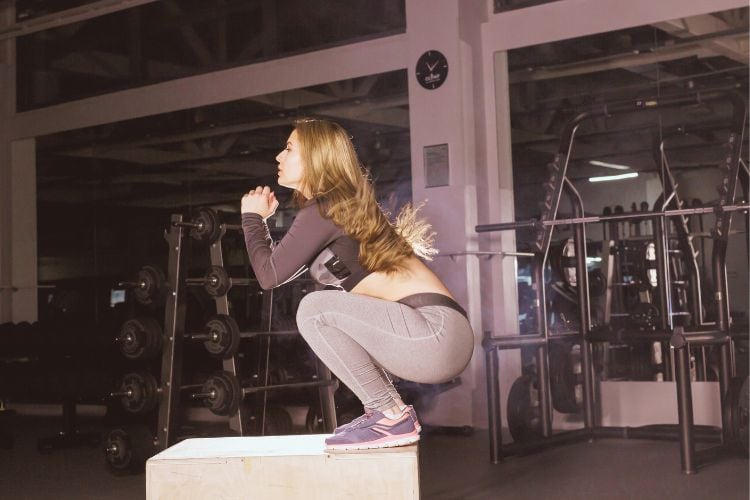 Woman doing jump squat in a 30-minute full body calisthenics cardio workout for fat loss and strength