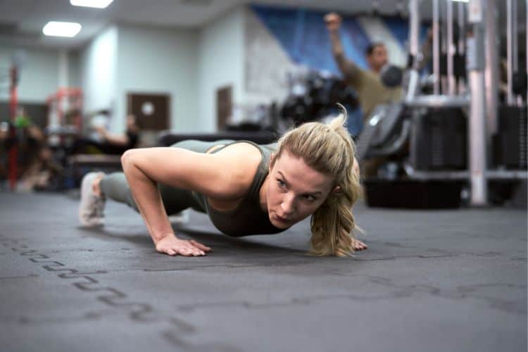 Woman doing burpees in a 20 minute calisthenics circuit workout routine