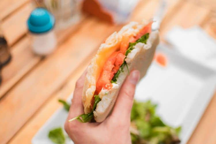Healthy cold lunch ideas for teens with wraps, fruit, and veggie sticks in a lunchbox