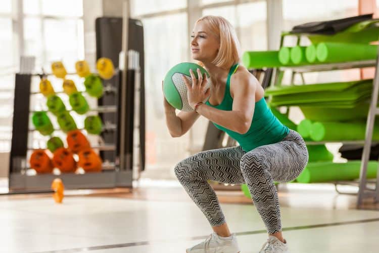 Woman performing squat to press with dumbbells during a 20-minute full body workout
