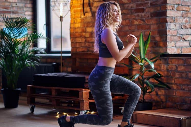 Woman performing squats with dumbbells during a 30 minute full body fitness routine