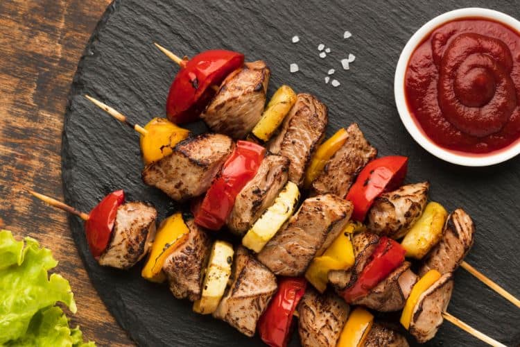Juicy grilled beef kebabs on skewers with colorful vegetables over a hot grill