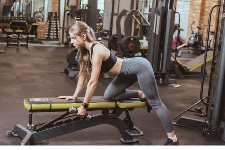 Woman performing dumbbell rows during a 45-minute upper body HIIT workout