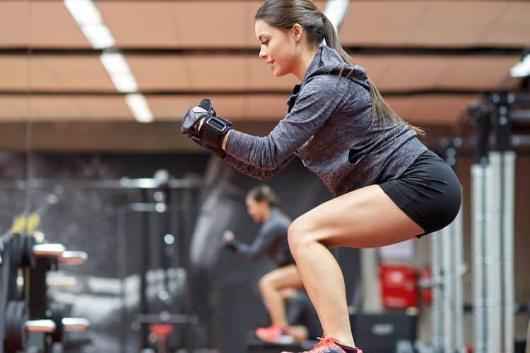 Woman performing jump squats in a 30 minute full body HIIT workout circuit