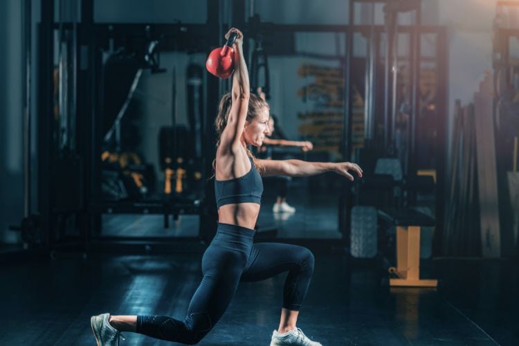 Woman performing kettlebell lunges in a 45-minute HIIT workout plan