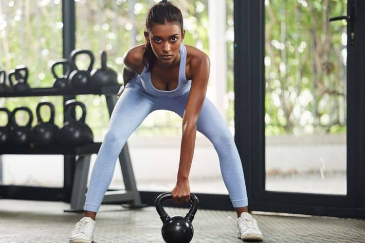 Woman performing kettlebell deadlift during a quick full body workout