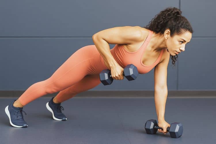 Woman performing dumbbell renegade row in the gym during a 35 minute full body dumbbell workout.
