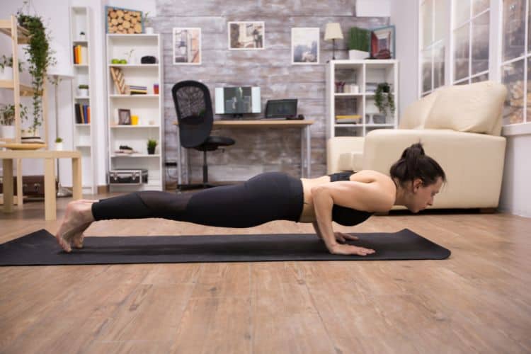 best full body bodyweight workout at home featuring a woman doing push-ups with Women’s Fit Club