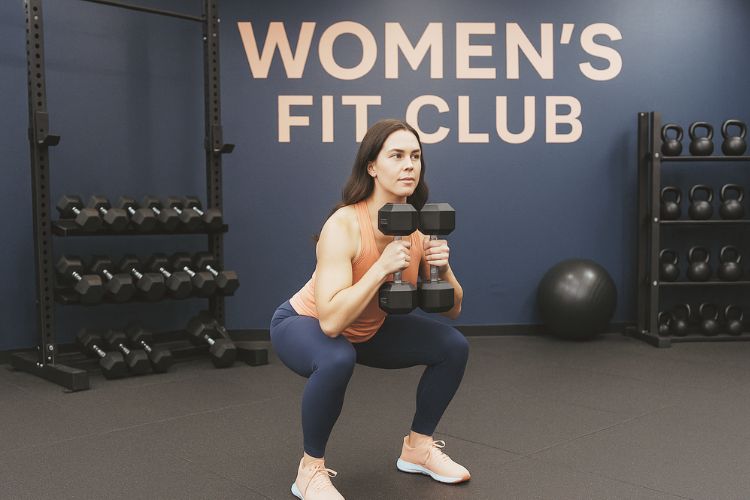 A woman performing a goblet squat during a 30-minute progressive overload leg workout.