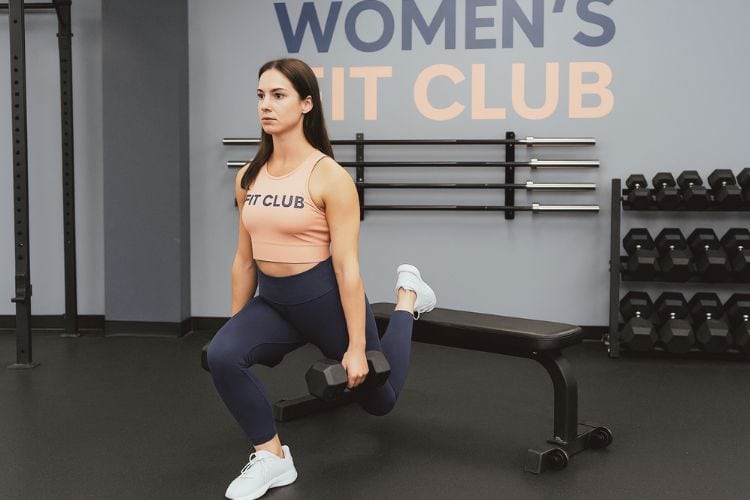 A woman performing a goblet squat during her 7-day progressive overload strength training routine