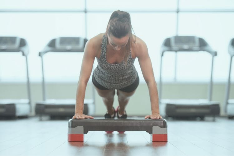 woman performing a push up exercise during a 15 minute no repeat HIIT workout