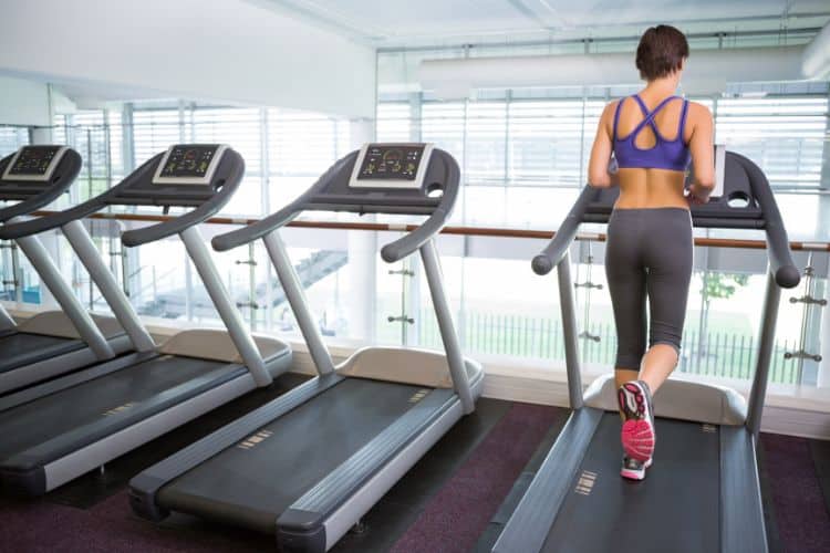 Woman smiling confidently while running on a treadmill during a 20-minute workout