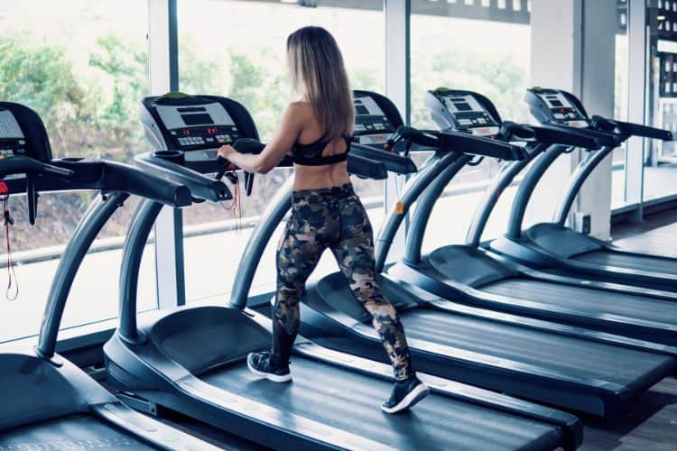 a woman confidently starting her running on a treadmill during a 10-minute