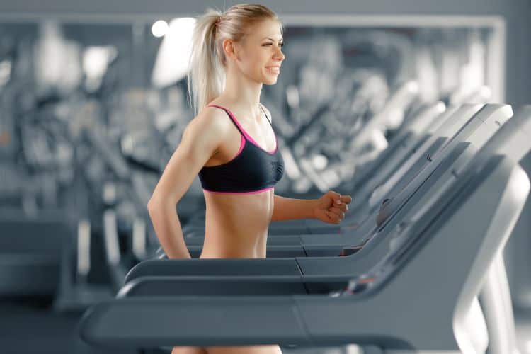 Woman performing a high-intensity interval on a treadmill during a 15-minute workout.