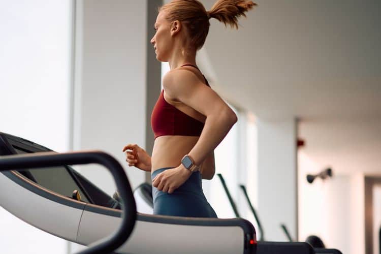 Woman running on a treadmill during a 30-minute treadmill workout.