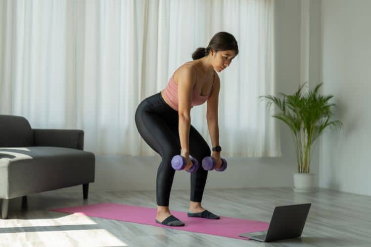 A person performing a dumbbell bent over row in a cozy living room during winter, following a 45-minute full body workout.