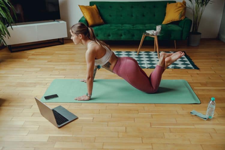 A comfortable home setup for a 30-minute no-equipment winter workout plan, featuring a yoga mat and water bottle.