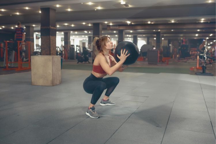 Woman performing perfect bodyweight squats, a key move in the 10-minute lower body workout plan.