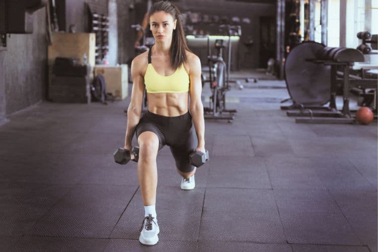 A Woman performing a dumbbell reverse lunges to work legs and core during 45-minute weight lifting dumbbell workout.