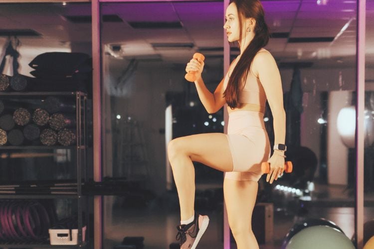 Woman performing a high-knee run workout for leg and glute during a 30-minute cardio workout for legs and glutes cardio.