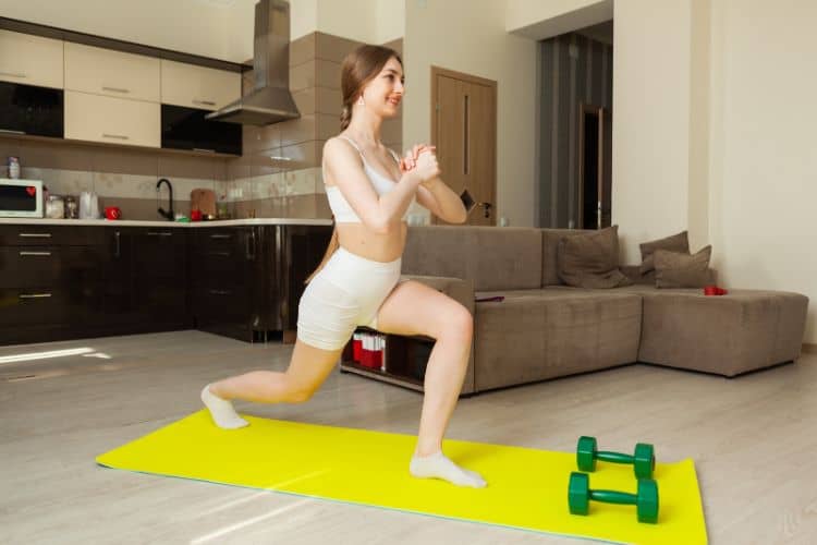 Woman performing a 7 minute full body workout at home in living room, demonstrating reverse lunges exercise.