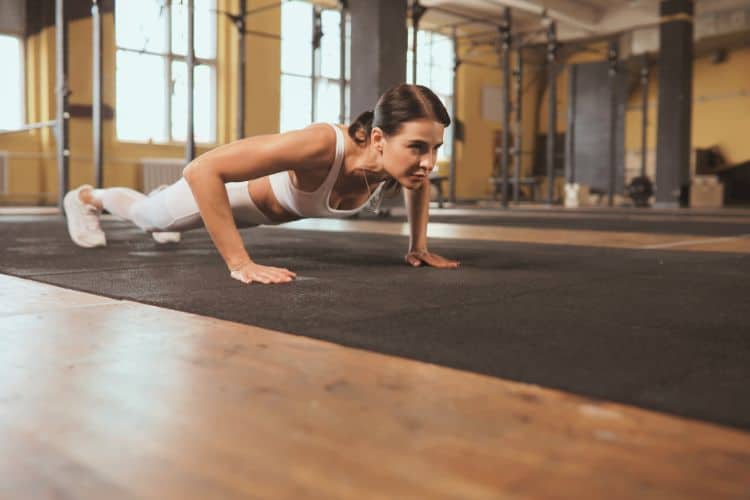 Woman performing bodyweight push ups in a 28-day full body calisthenics workout program.