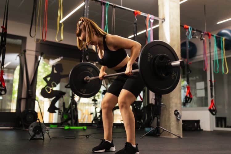 Bent-over barbell row during 35-minute barbell complex workout – elbows driving back, torso braced, full grip on bar.