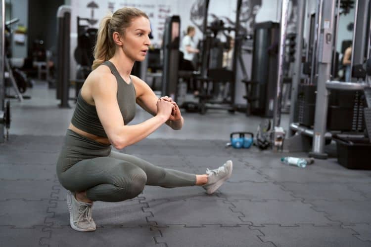 Woman performing side lunges in the gym during 45 minute no repeat workout.