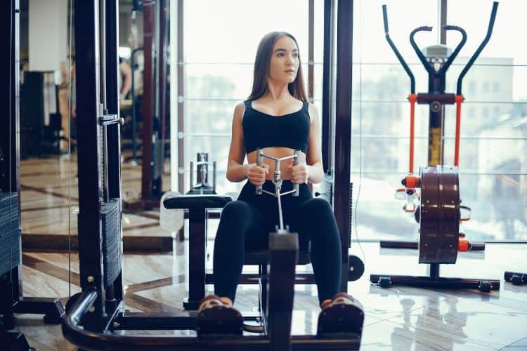 Woman performing a seated cable row, a key exercise for the best cable back workout for building muscle and strength.