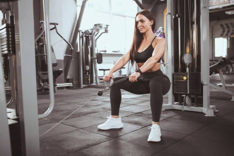 Person performing a 30 minute cable front squat for quads with a rope attachment, demonstrating an upright torso and constant tension on the quads.