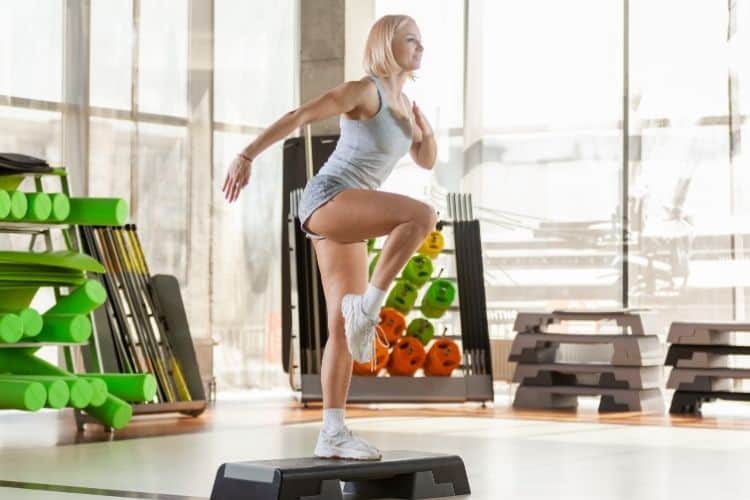 Woman performing a burpee during a 30-minute HIIT workout for busy moms, showcasing proper form.