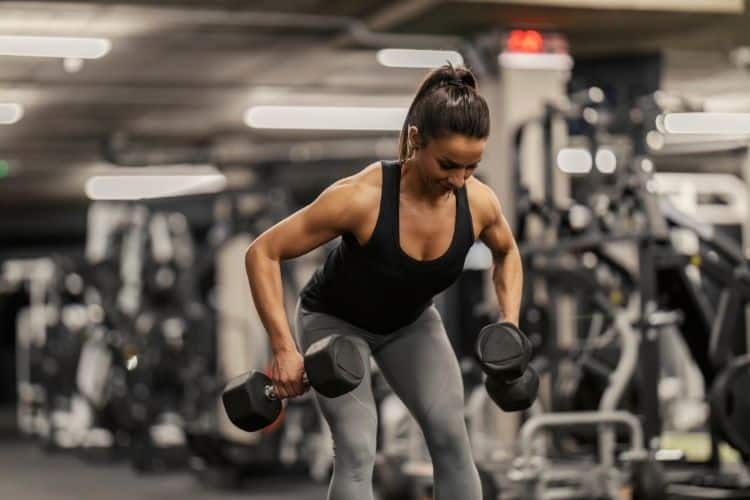 Woman performing an upper body dumbbell fly superset workout for chest and arms with perfect form during a 14 day upper body superset dumbbell workout.