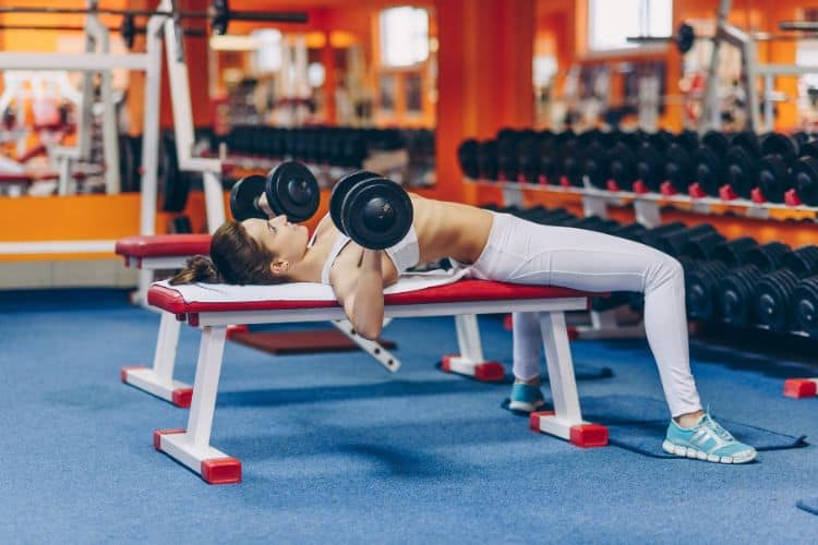 Person performing a dumbbell press during Day 1 of the SplitLean 8-day progressive strength workout program.
