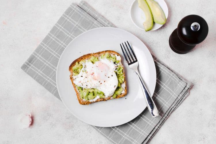 Close-up of a deliciously warm and best-ever avocado toast with eggs winter breakfast.
